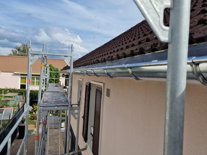 Gouttières : pose d'une gouttière neuve sur façade, sous échafaudage