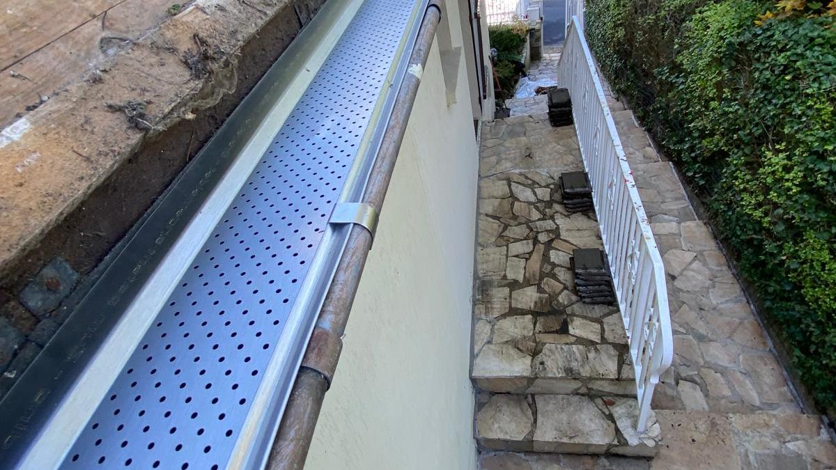 Gouttière nettoyée et équipée d'une grille pare-feuilles