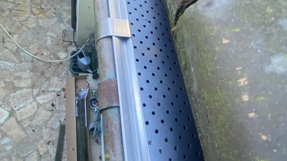 Gouttière protégée par une grille le long d'un versant