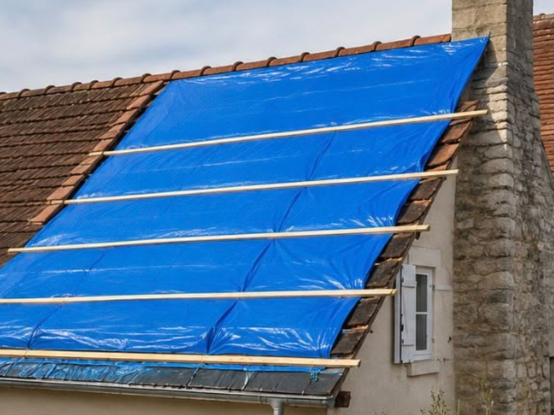 Urgence toiture : bâche fixée et lestée par des tasseaux pour mettre la toiture hors d'eau