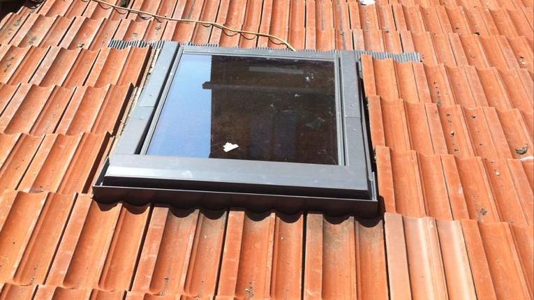 Fenêtre de toit posée sur une couverture en tuiles
